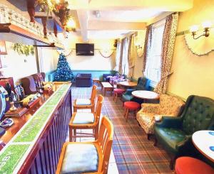 a room with a bar with chairs and a christmas tree at The Mill Hotel in Bedford