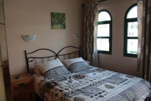 een slaapkamer met een bed en 2 ramen bij Bungalow Duna Flor Verde in Maspalomas