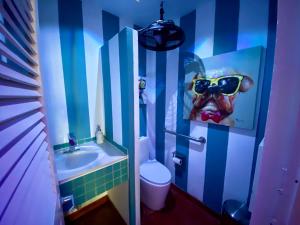 a bathroom with a sink and a toilet with a painting of a cow at Blue Horizon Boutique Resort in Vieques