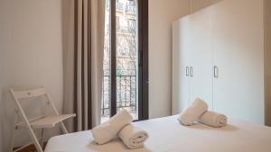 1 dormitorio con 1 cama con 2 almohadas y ventana en Apartamento de 3 dormitorios en Barcelona
