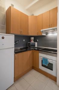 cocina con armarios de madera y horno de fogón blanco en Apartamento de 3 dormitorios en Barcelona
