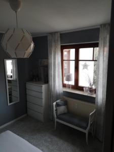 ein Schlafzimmer mit einem Stuhl, einem Spiegel und einem Fenster in der Unterkunft Ferienwohnung Schreckenbach in Sankt Egidien