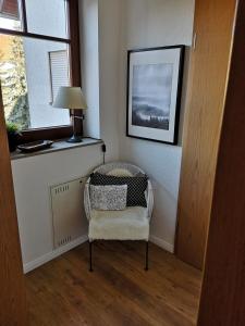Zimmer mit einem Stuhl, einer Lampe und einem Fenster in der Unterkunft Ferienwohnung Schreckenbach in Sankt Egidien