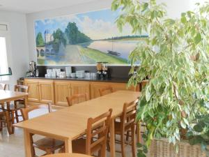 una sala da pranzo con tavoli e un dipinto sul muro di Hotel du Parc a Châteauneuf-sur-Loire