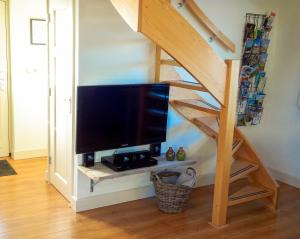 ein Wohnzimmer mit einem TV unter einer Treppe in der Unterkunft Molenzicht in Sint Maarten