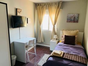 a bedroom with a bed and a desk and a window at BYOR City Rooms in Las Palmas de Gran Canaria