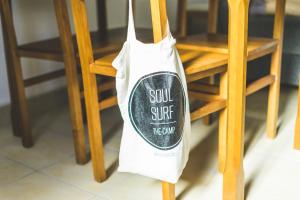 a white bag hanging from a chair with a soul surf theore at SoulSurfcamp Portugal in Peniche