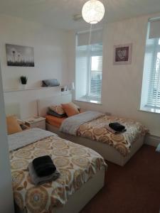 - une chambre avec 2 lits et 2 fenêtres dans l'établissement Rhodri Apartment with Sea Views and Sun Terrace, à Trearddur