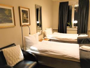 a hotel room with two beds and a couch at Rum i Centrum in Vetlanda