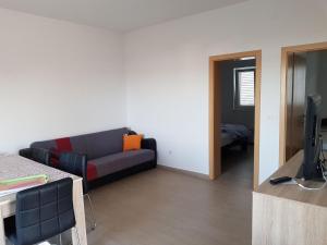 a living room with a couch and a television at Contemporary Apartment in Neviđane near Sea in Neviđane
