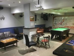 a room with a fireplace and a pool table at The Loco in Doncaster