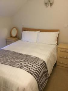 um quarto com uma cama grande e lençóis brancos em The Loco em Doncaster