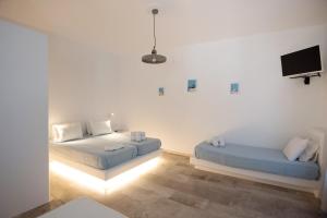 Pokój z 2 łóżkami i telewizorem z płaskim ekranem w obiekcie Eleana Studios w mieście Ambelas