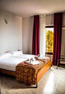 Hotel Corte Dal Castello في كولا دي لاتيزي: غرفه فندقيه بسرير ونافذه