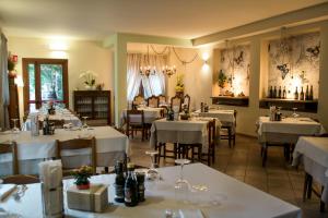 Hotel Corte Dal Castello في كولا دي لاتيزي: مطعم به طاولات وكراسي به مفارش بيضاء
