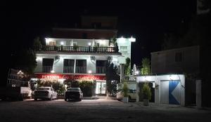 a building with cars parked in a parking lot at night at Pension los Verdiales in La Herradura