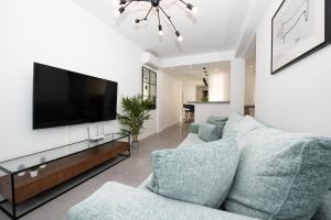 uma sala de estar com um sofá e uma televisão de ecrã plano em Benigno Premium Center em Málaga