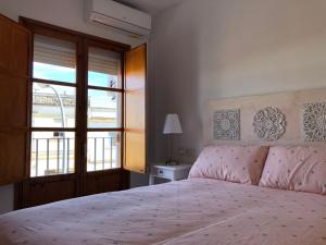 een slaapkamer met een groot bed en een raam bij APARTAMENTOs IGLESIA DE SANTIAGO in Jerez de la Frontera