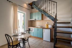 a kitchen with a table and a staircase in a room at Barax Apartments in Agios Georgios