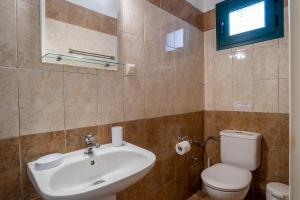 a bathroom with a sink and a toilet at Barax Apartments in Agios Georgios