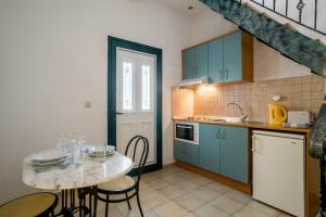 a kitchen with blue cabinets and a table with chairs at Barax Apartments in Agios Georgios +7 photos