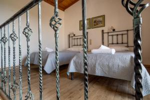 a bedroom with two beds and a staircase at Barax Apartments in Agios Georgios