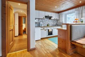 a kitchen with white cabinets and a wooden floor at Terrassenapartment Maria in Umhausen +9 photos