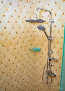 y baño con ducha y pared de azulejos. en ASOUR HOTEL en Goris