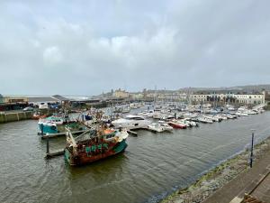 a group of boats are docked in a harbor at 46 Y Lanfa in Aberystwyth