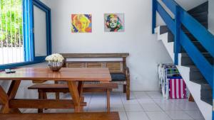 uma sala de jantar com uma mesa de madeira e escadas azuis em Casa VERDE - A 70 Metros da Areia da Praia dos Ingleses - 6 Pessoas em Florianópolis