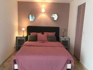 - une chambre avec un grand lit rose et 2 tables dans l'établissement MAS DE LA FADETO, aux Baux-de-Provence