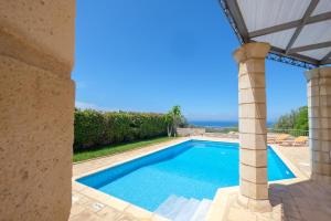 - une piscine dans une villa avec vue sur l'océan dans l'établissement Trochalo Villas, à Stoupa