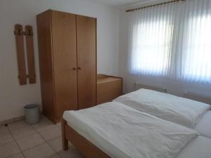 a bedroom with a bed and a wooden cabinet at Ferienwohnung Sewenig in Müden