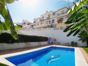 a swimming pool in front of a building at Villa Pinomar - Sleeps 8 - Burriana Beach in Nerja