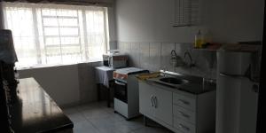 a small kitchen with a sink and a microwave at Vista Bela in Campos do Jordão