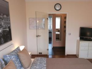 Una sala de estar con un sofá y un reloj en la pared. en Apartment S - perfect stay, en Leipzig