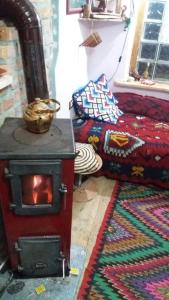 a living room with a wood stove and a bed at At Home Hostel in Korçë