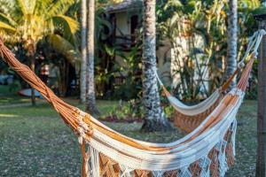 two hammocks in a yard with palm trees at Aldeia do Mar Hotel in Itacaré