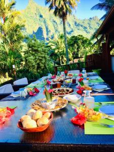 una larga mesa azul con platos de comida. en Eco Lodge Village Temanoha en Paopao