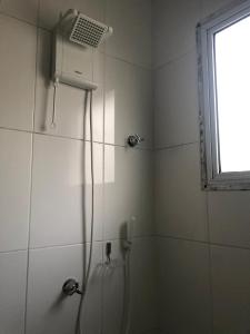 eine Dusche im Bad mit Fenster in der Unterkunft Casa em Pauba in São Sebastião