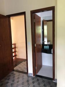 einen Flur mit Tür und Spiegel in einem Zimmer in der Unterkunft Casa em Pauba in São Sebastião
