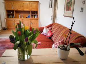 a living room with a couch and a table with flowers at Ferienwohnung Aurora in Garmisch-Partenkirchen