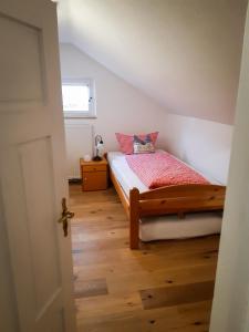 a bedroom with a bed and a wooden floor at Ferienwohnung Aurora in Garmisch-Partenkirchen