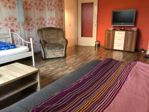 a living room with a bed and a tv at Misha,s Place in Duisburg