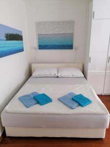 a white bed with two blue towels on it at Zagreb Studio 39 Kranjčevićeva in Zagreb