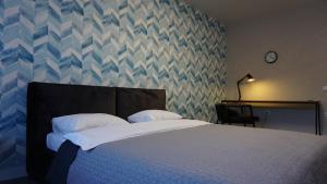 Un dormitorio con una cama con una pared azul y gris en Красивая квартира в парке, en Kiev
