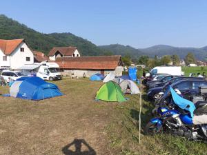 un grupo de tiendas de campaña y motocicletas estacionadas en un campo en Dragacevska avlija - Camp, en Guča