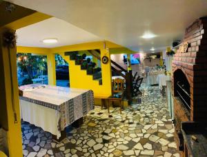 a dining room with a table and a fireplace at Pousada Toca dos Coelhos in Arraial do Cabo