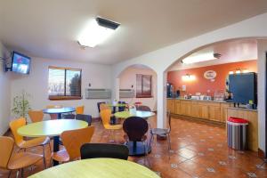 a restaurant with tables and chairs and a kitchen at Super 8 by Wyndham Las Cruces/White Sands Area in Las Cruces