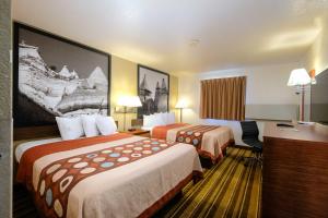 a hotel room with two beds and a desk at Super 8 by Wyndham Las Cruces/White Sands Area in Las Cruces
